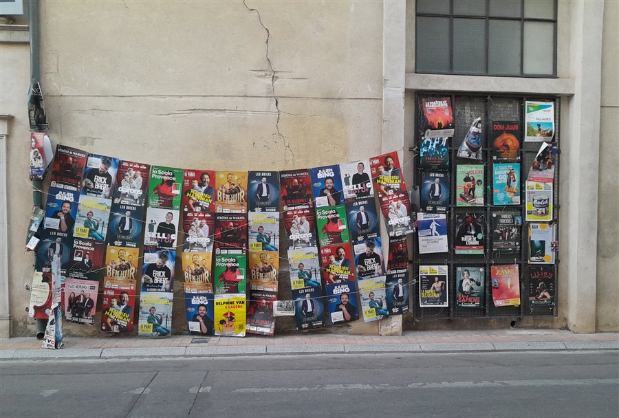 Manifesti del festival teatrale di Avignone affissi lungo una strada