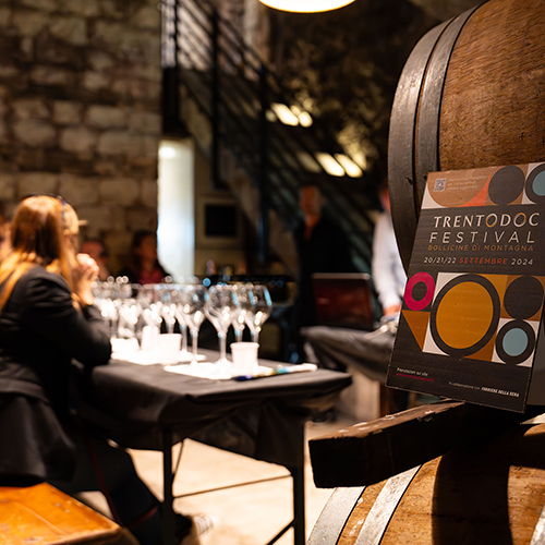Degustazione in cantina durante il Trentodoc Festival, tra botti e locandina dell'evento