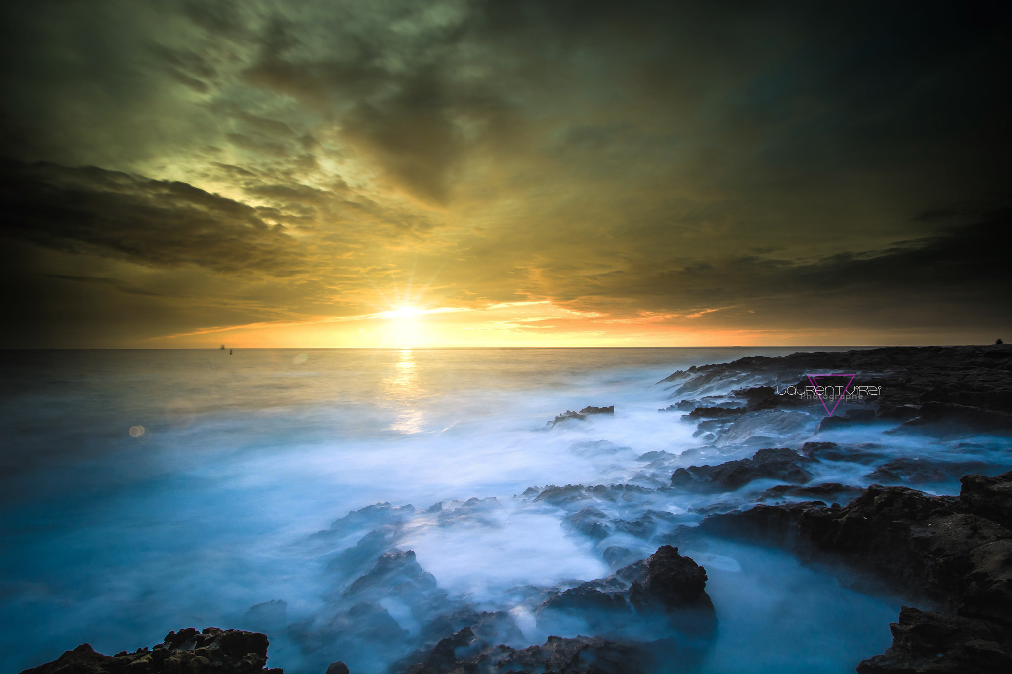 Tramonto sul Mar Mediterraneo, onde che si infrangono sugli scogli